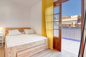 Bedroom w/ access to the balcony and queen- size bed