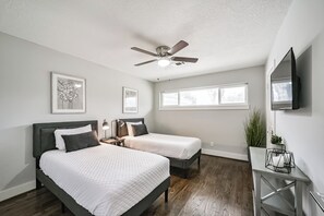 Bright and welcoming third bedroom offers two twin beds, a smart TV, making it perfect for kids or friends traveling together. Light-filled and practical, with extra blankets provided. Guests in this room also have access to the shared bathroom with a bathing tub and shower.