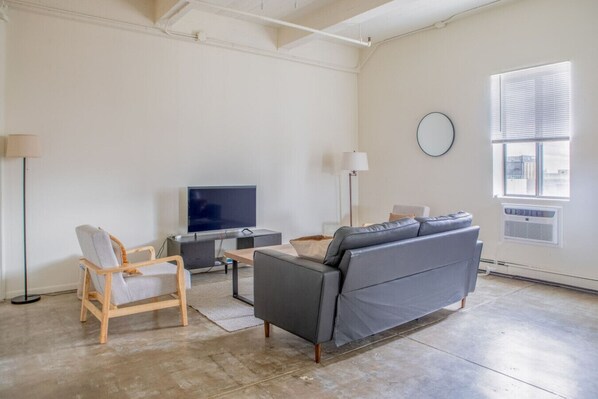 Spacious living room with lofted ceilings and skyline views