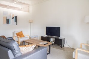 Spacious living room with lofted ceilings and skyline views