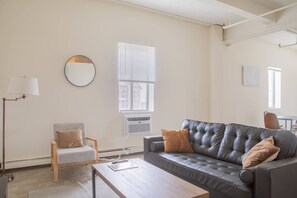 Spacious living room with lofted ceilings and skyline views