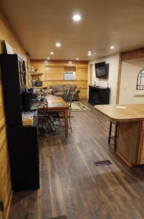 Kitchen, dining and living room areas. Coffee bar and trash can hutch.