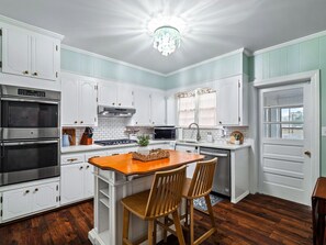Sunshine streams into this dreamy kitchen, illuminating the crisp white cabinets and warm wood floors.  Perfect for a cozy morning coffee ☕️. #dreamkitchen