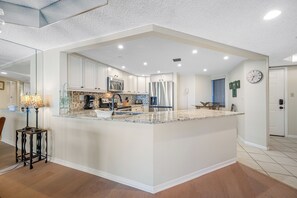 Enjoy cooking in this fully equipped, modern kitchen with sleek countertops and plenty of space.