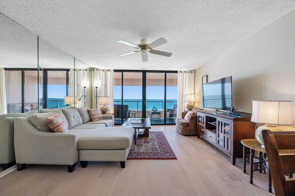 Relax in this bright, open living space with stunning floor-to-ceiling views of the ocean.