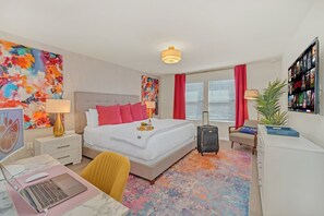 Spacious master suite with workspace, bold decor, and comfort