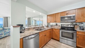 Cook up your favorite meals in this fully equipped kitchen featuring stainless steel appliances, granite countertops, and warm wood cabinetry. Enjoy Gulf views while preparing snacks or sipping coffee at the breakfast bar.