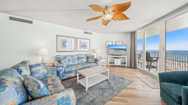 Relax in this bright and breezy beachfront living room, featuring vibrant coastal décor and panoramic views of the Gulf. Plush seating and a flat-screen TV make it perfect for unwinding, while sliding glass doors open to a private balcony just steps from 