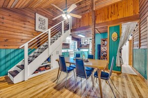 Full kitchen with dining space with lots of color and charm! Stairs leading to the lofted bedroom.