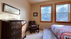Bedroom: dresser, chair, window. Cozy space.
