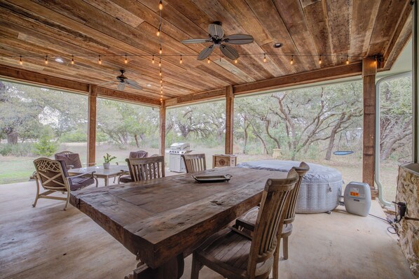 Covered patio with a rustic dining table, ceiling fans, and beautiful views—ideal for outdoor meals.