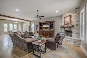 Plenty of seating, a fireplace, and natural light make this living room ideal for family time.