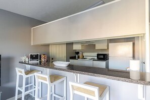 Start your mornings at the breakfast bar — fully equipped kitchen with everything you need for a home-cooked meal or quick coffee before hitting the beach!
