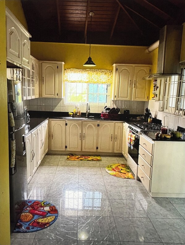 Full kitchen with manual lit gas stove, kettle, coffee maker, toaster.
