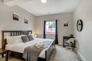 A spacious bedroom with a king-size bed, cozy decor, a desk for work or study, and a pack 'n play for little ones, making it perfect for families.





