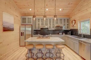 Open concept kitchen provides counter seating along with a large dining table.