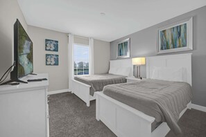 Relax in this cozy bedroom featuring two comfortable beds, modern decor, and natural light for a restful stay.