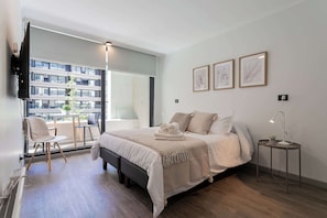 Experience modern comfort in this stylish bedroom with natural light and a cozy seating area, perfect for relaxation after a day of adventure.