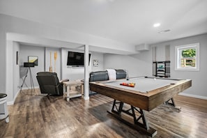 Cozy accommodations in downstairs game room & enjoy a game of pool with friends!