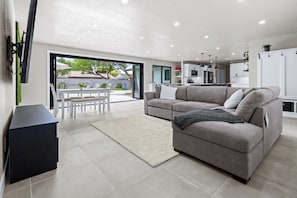 Modern living room with huge sofa and backyard access