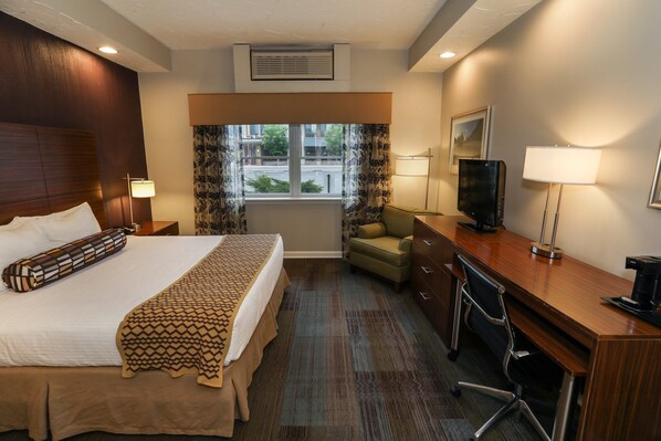 Comfortable guest room with a plush bed, work desk, and plenty of natural light.