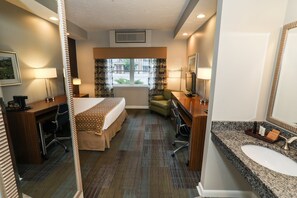 Well-appointed room featuring a cozy bed, seating area, and convenient workspace.