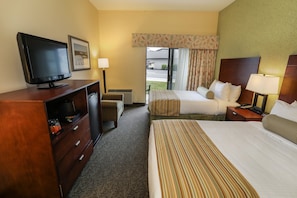 Cozy guest room with a comfortable bed, TV, and plenty of natural light, perfect for a relaxing stay.