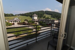 A peaceful balcony retreat with breathtaking views of rolling green hills and the resort below.