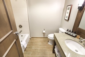 Modern bathroom with a large vanity and shower/tub combo, providing a refreshing experience.