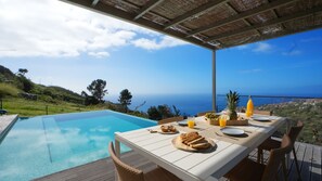 Start your morning at Villa Amêndoa by LovelyStay with a delightful breakfast by the infinity pool. Savor fresh pastries, tropical fruits, and juice while enjoying panoramic ocean views in the heart of Calheta’s serene landscape. #peace #dreamholiday