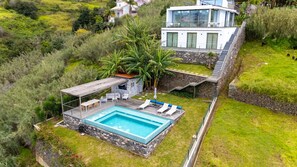 Modern villa with stunning hillside location, private pool, spacious terraces, lush garden, and breathtaking mountain views. #serenity #villaamêndoa #pool #garden