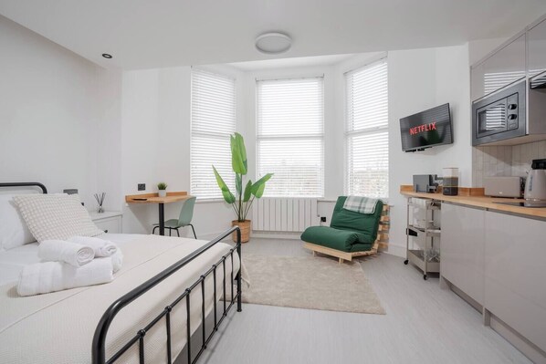 Room Features: 

-1 x Double Bed 
-1 x Sofa bed for 1 guest
-Plugs in bedside table (direct USB plug available) 
-Dedicated workspace 
-Smart TV with Netflix 
-Open space with hangers
-Washing machine
-Private mini fridge with freezer
-Kitchenette