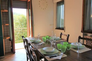 cucina con tavolo e sedie e balcone annesso