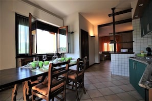 cucina con tavolo e finestra a doppia anta