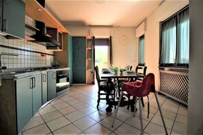cucina spaziosa con tavolo, sedie e seggiola per bambini 
