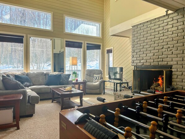 Huge primary living space with a cathedral ceiling & wood-burning fireplace