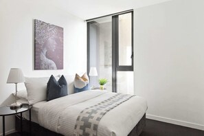 The 2nd bedroom with a double sized bed & plush pillows.