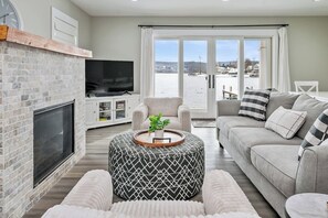 Cozy up in this dreamy lakefront living room! With a warm fireplace, plush seating, and stunning water views, it’s the perfect spot to unwind after a day of exploring. Grab a blanket, pour a glass of wine, and soak in the peaceful vibes.