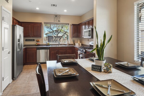 Welcome to Saguaro Sunrise! Your desert haven for seasonal stays. The home features a spacious kitchen and large dining table.