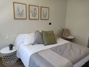 Cozy bedroom retreat with elegant decor and soothing botanical art, perfect for a restful stay.