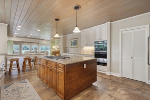 The expansive gourmet kitchen is a chef's paradise, boasting state-of-the-art appliances and ample seating for guests to gather and enjoy.