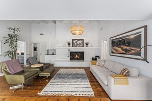 Cozy up in this stylish living room with a white brick fireplace (not for use.), plush seating, and warm decor. Perfect for movie nights, relaxing by the fire, or spending time with loved ones.