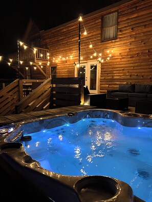 Unwind under the stars as soft string lights cast a cozy glow around the bubbling hot tub. A perfect setting for evening relaxation or a romantic night.