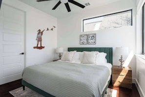 King bedroom with large windows and fresh linens