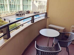 Step out onto the balcony, where you’ll find two comfortable chairs and a table perfectly positioned to enjoy a serene view of the pool. It’s the ideal spot for morning coffee or evening relaxation.