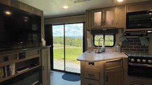 Modern kitchen with mountain views framed perfectly through sliding glass doors.