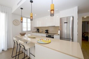 Another view of the kitchen with breakfast bar for two guests