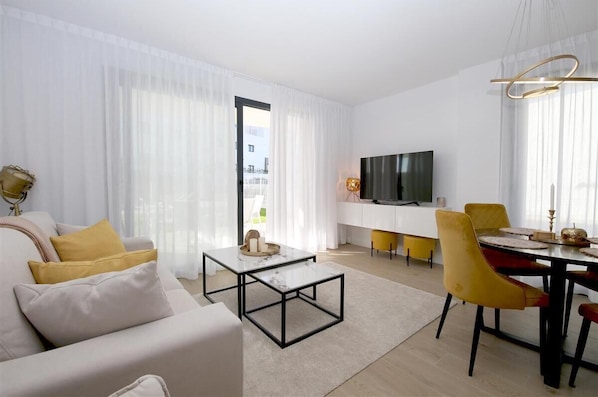 Bright and stylish lounge area with dining area for four guests and access to the terrace