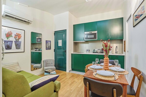 Salon avec canapé, TV, espace repas pour 4 personnes