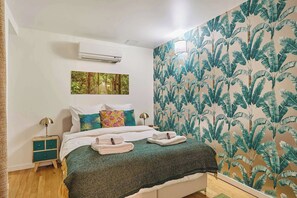 Chambre avec lit double, TV et salle de douche attenante
